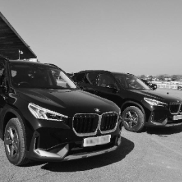 A couple of black cars parked in a parking lotDescription automatically generated