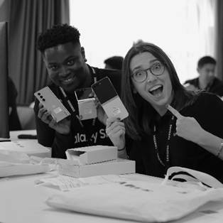 A person and person holding up cell phonesDescription automatically generated