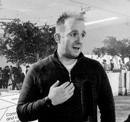 A person standing in front of a microphoneDescription automatically generated