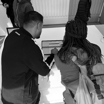 A group of people looking at a computerDescription automatically generated